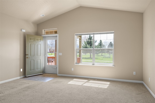 carpeted foyer featuring baseboards and lofted ceiling
