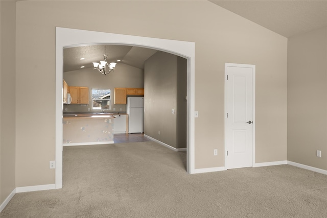 unfurnished living room featuring arched walkways, vaulted ceiling, baseboards, carpet floors, and a chandelier