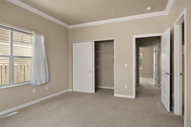 unfurnished bedroom featuring carpet floors, baseboards, visible vents, and ornamental molding