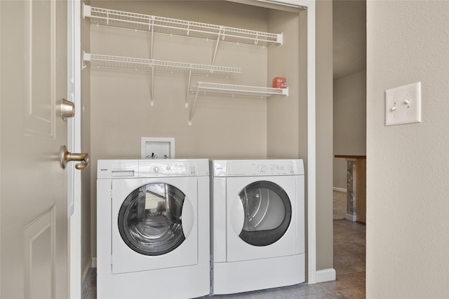 laundry room with baseboards, tile patterned flooring, laundry area, and washing machine and clothes dryer