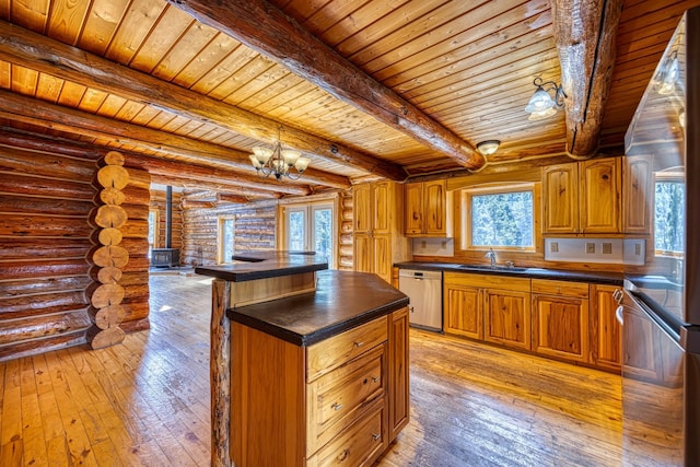 kitchen featuring a sink, dark countertops, log walls, stainless steel dishwasher, and light wood-style floors