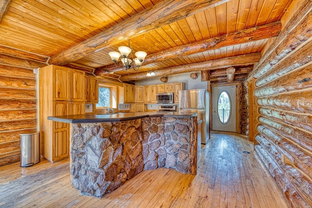 kitchen featuring light wood finished floors, rustic walls, appliances with stainless steel finishes, and wood ceiling