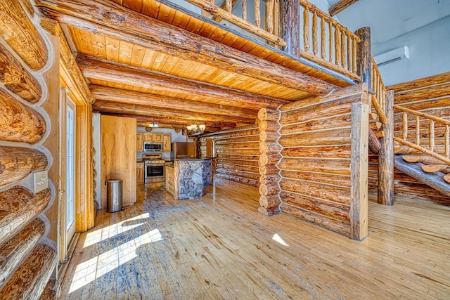 interior space featuring light wood finished floors, stairs, rustic walls, and beam ceiling