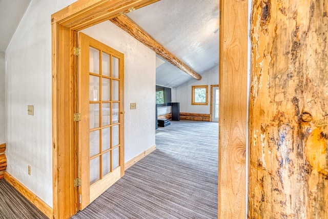 corridor featuring carpet, baseboards, and vaulted ceiling with beams