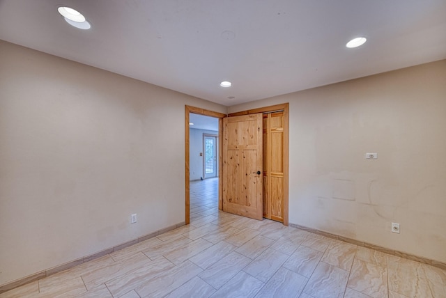 spare room with baseboards and recessed lighting