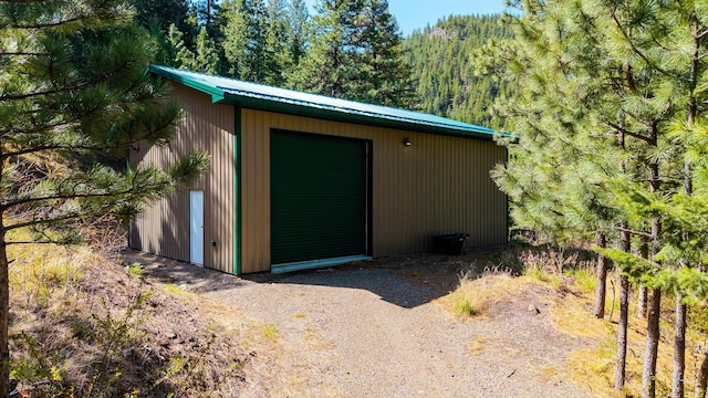 view of outbuilding featuring a forest view and an outbuilding