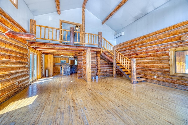 149 Novak Creek Ln, Cascade, MT 59421 - unfurnished living room with high vaulted ceiling, wood-type flooring, beamed ceiling, log walls, and stairs