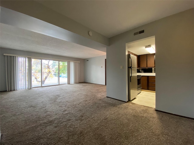 unfurnished living room with light colored carpet and visible vents