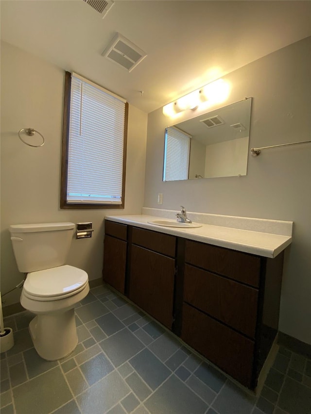 bathroom featuring vanity, tile patterned floors, toilet, and visible vents