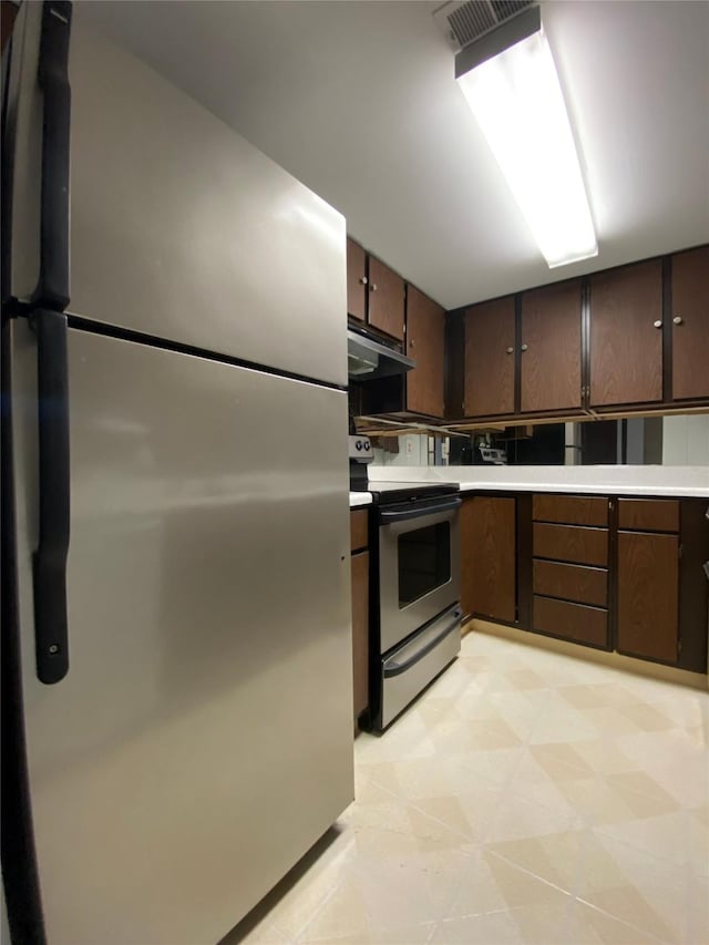 2300 14th Ave S # 5, Great Falls, MT 59405 - kitchen featuring light countertops, appliances with stainless steel finishes, dark brown cabinets, and extractor fan