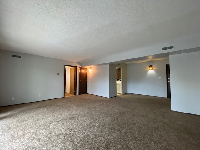 carpeted empty room with visible vents and a textured ceiling