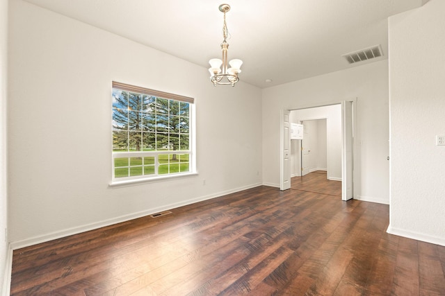spare room with visible vents, dark wood finished floors, baseboards, and a chandelier