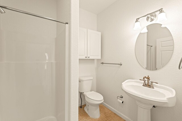 154 Palmer Dr, Kalispell, MT 59901 - bathroom with toilet, baseboards, tile patterned floors, and a shower