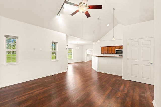 unfurnished living room with ceiling fan, track lighting, high vaulted ceiling, dark wood finished floors, and visible vents