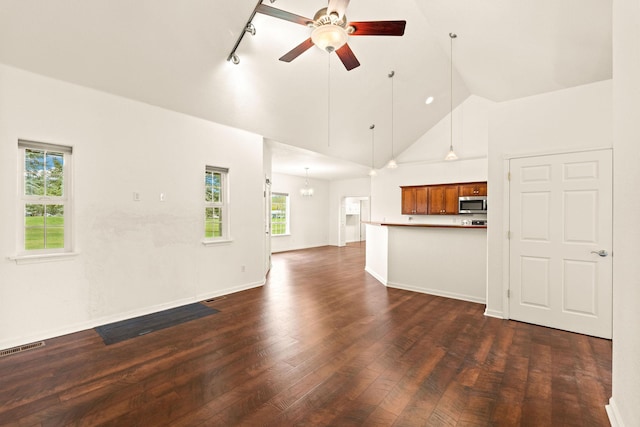 unfurnished living room with dark wood-style flooring, track lighting, high vaulted ceiling, a ceiling fan, and visible vents
