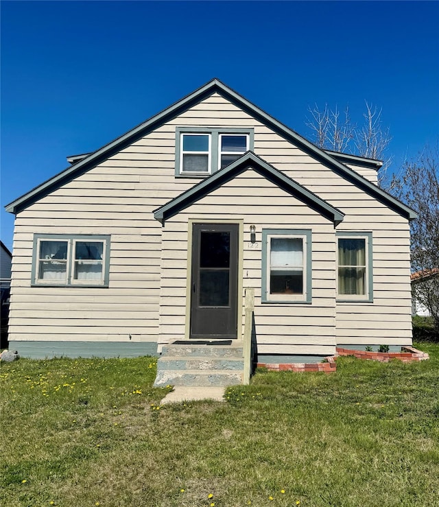 view of front of property featuring entry steps and a front lawn