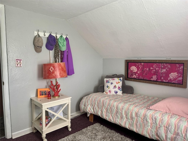 carpeted bedroom featuring baseboards and lofted ceiling