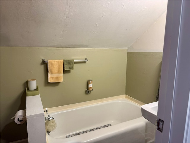 full bathroom featuring vaulted ceiling and a garden tub