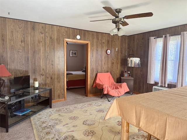 bedroom with baseboards, carpet flooring, ceiling fan, and wooden walls