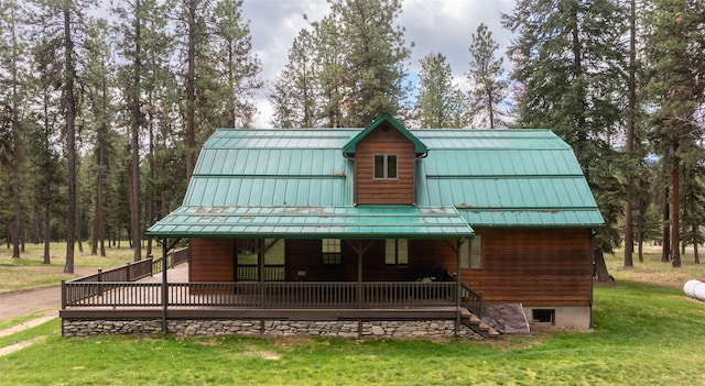 view of front of home with a front lawn, covered porch, metal roof, and a standing seam roof