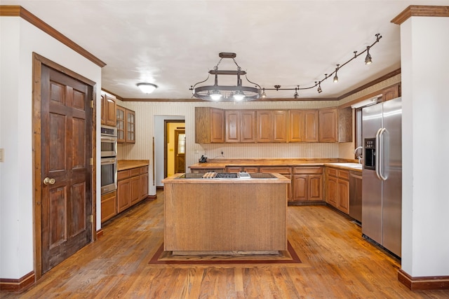 kitchen featuring crown molding, appliances with stainless steel finishes, and light wood finished floors