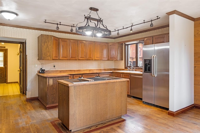 kitchen featuring a center island, a sink, appliances with stainless steel finishes, and rail lighting