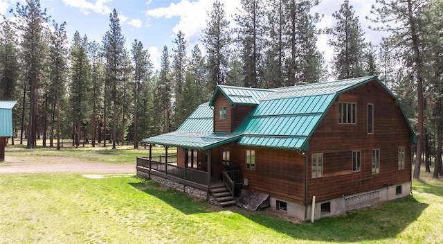 exterior space with metal roof, a yard, a standing seam roof, and covered porch