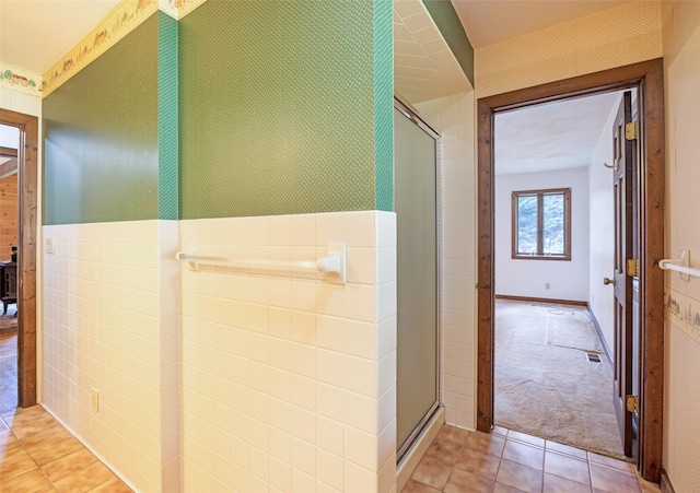 hall with wallpapered walls and light tile patterned floors