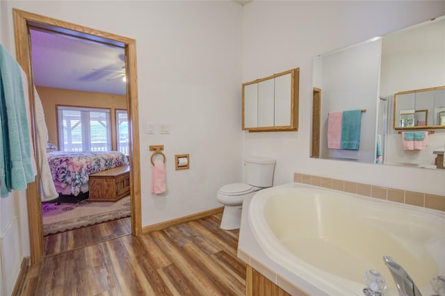 ensuite bathroom featuring a garden tub, wood finished floors, toilet, ceiling fan, and ensuite bath