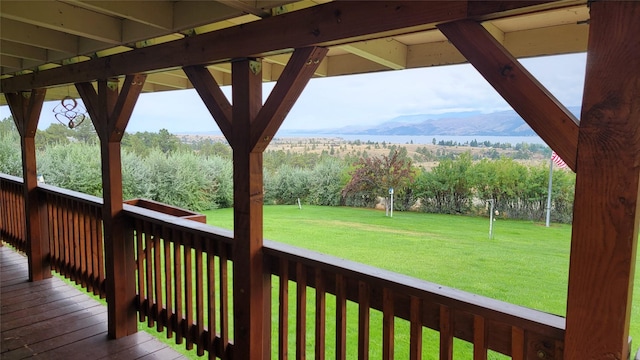 wooden deck with a lawn and a mountain view
