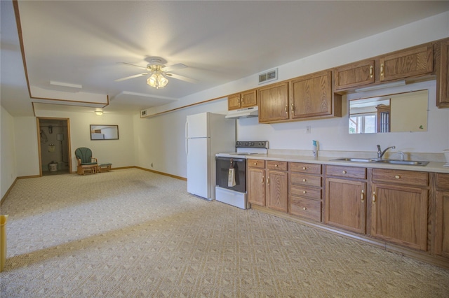 kitchen with visible vents, brown cabinetry, white appliances, under cabinet range hood, and a sink