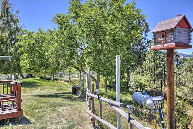 view of yard featuring central AC and fence