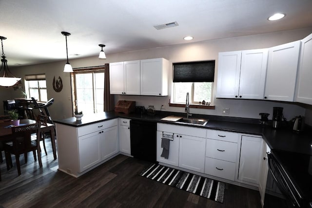 kitchen featuring visible vents, a peninsula, dark countertops, black dishwasher, and a sink