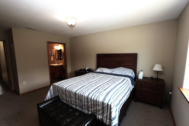 carpeted bedroom featuring visible vents, baseboards, and ensuite bathroom