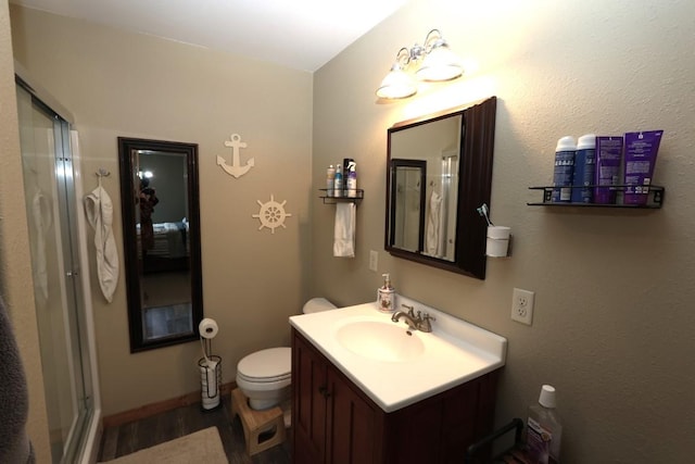 full bathroom with toilet, a shower stall, wood finished floors, and vanity