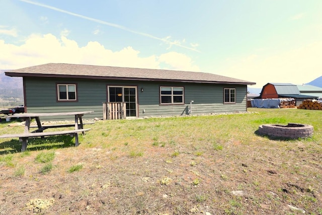 rear view of house featuring a lawn and an outdoor fire pit