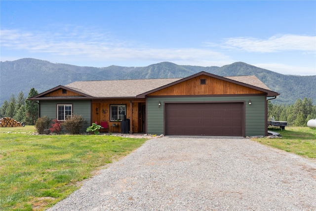 70 Moccasin Ln, Thompson Falls, MT 59873 - view of front of property featuring a mountain view, driveway, a front lawn, and a garage