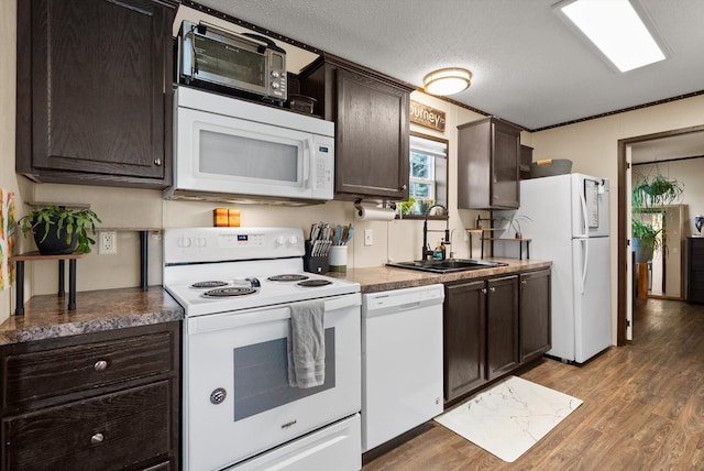 110 Van Sant Rd Unit 4, Kalispell, MT 59901 - kitchen featuring white appliances, a sink, wood finished floors, dark brown cabinetry, and a textured ceiling