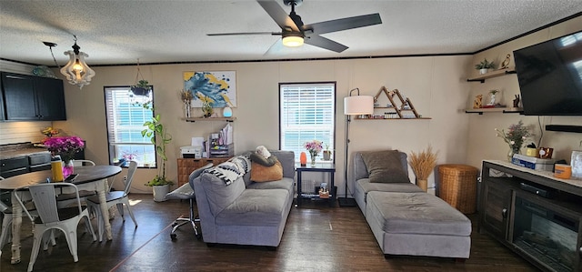 living room with dark wood-type flooring, a ceiling fan, a textured ceiling, and ornamental molding