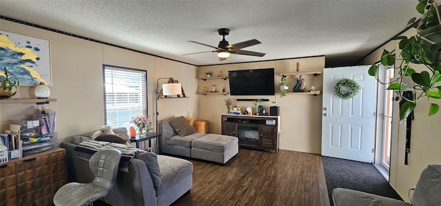 living area with a glass covered fireplace, a ceiling fan, a textured ceiling, and wood finished floors