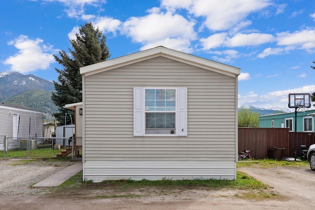 110 Van Sant Rd Unit 4, Kalispell, MT 59901 - view of home's exterior with a mountain view, fence, and an outdoor structure
