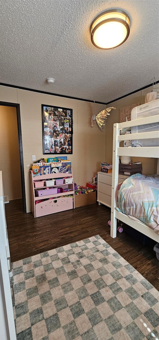 bedroom with a textured ceiling and wood finished floors