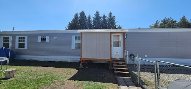 view of outbuilding with a trampoline, fence, and entry steps