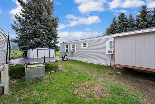 110 Van Sant Rd Unit 4, Kalispell, MT 59901 - view of green lawn with a storage unit, an outdoor structure, and a trampoline
