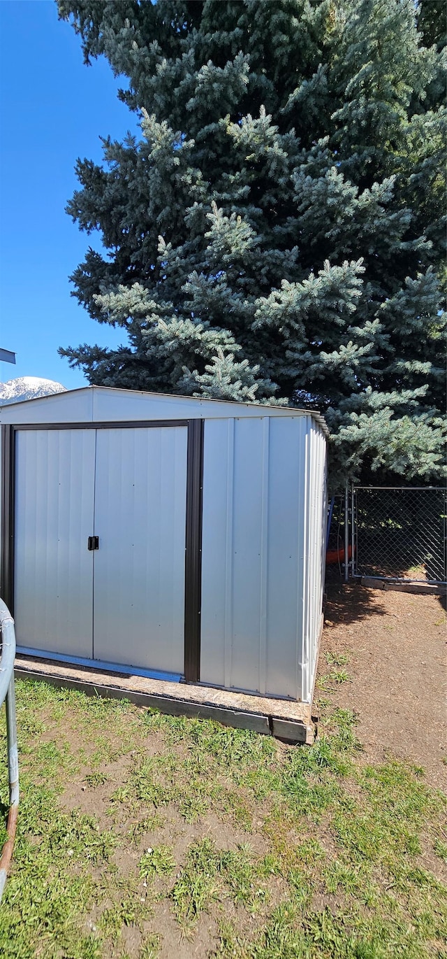 view of shed featuring fence
