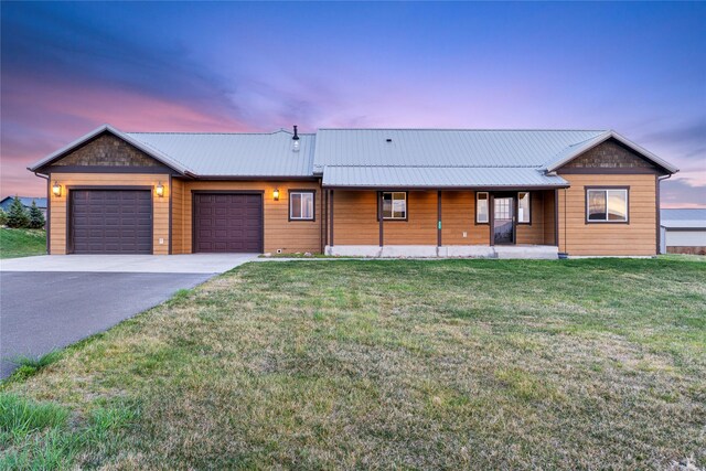 20 Windy Meadow Dr, Townsend, MT 59644 - view of front of house featuring an attached garage, aphalt driveway, a porch, a yard, and metal roof