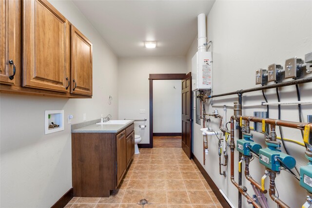 20 Windy Meadow Dr, Townsend, MT 59644 - washroom featuring baseboards, hookup for a washing machine, a sink, cabinet space, and water heater