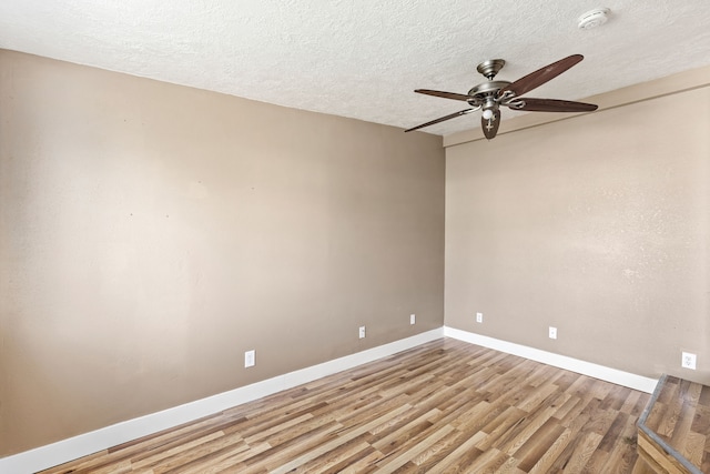 spare room featuring baseboards, a textured ceiling, ceiling fan, and wood finished floors
