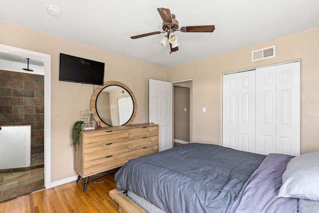 bedroom with ensuite bath, a ceiling fan, baseboards, visible vents, and a closet