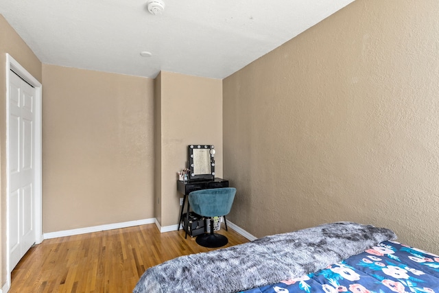 bedroom with baseboards and wood finished floors
